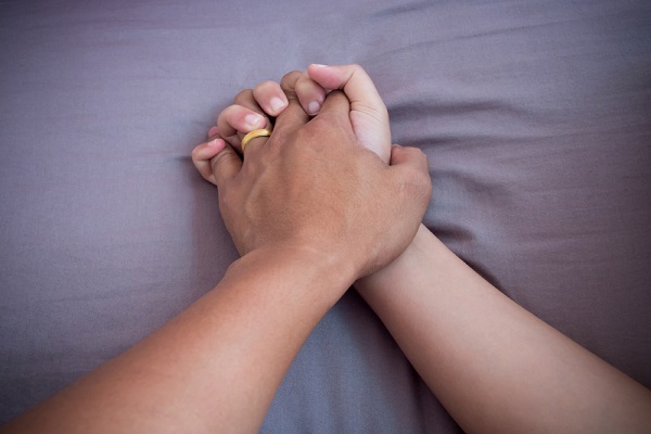 Lover hands on bed